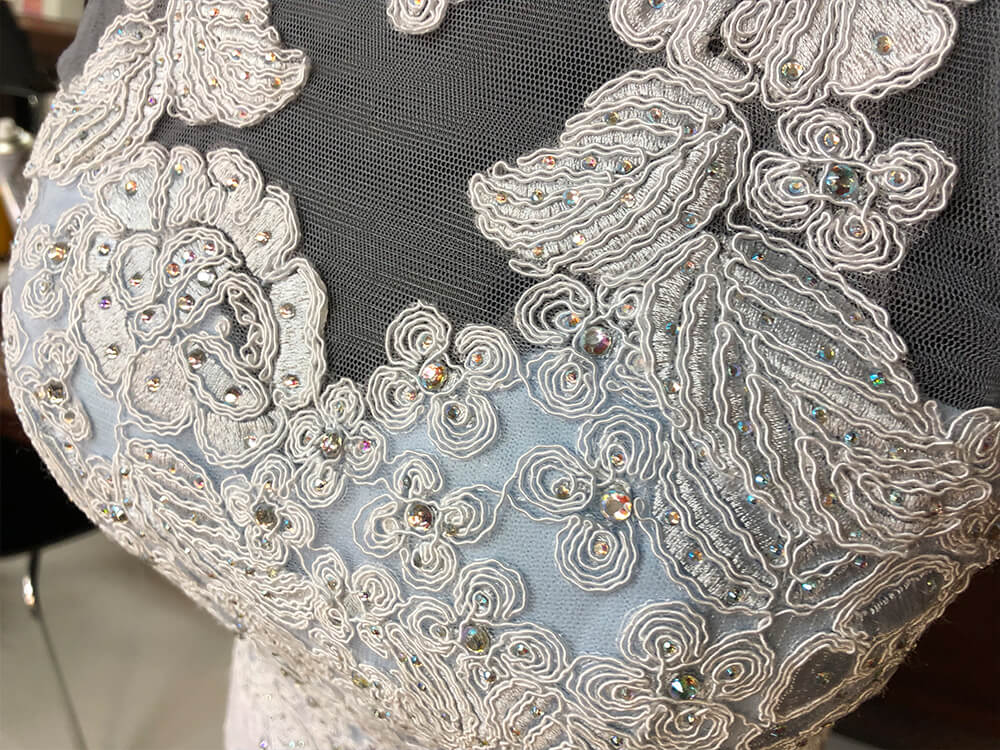 フラワーモチーフの刺繍とビーズが美しいロングドレスのアップ画像